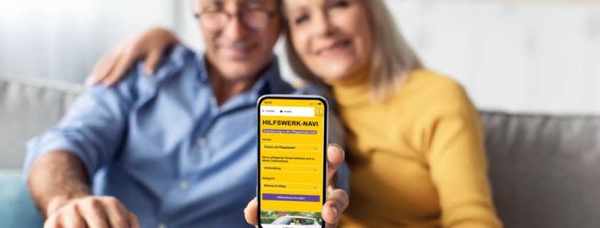 Älteres Paar zeigt Hilfswerk Navi App am Handy